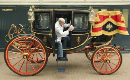 El restaurador de carruajes Dave Evans limpia la carroza landó real de 1902 en las Caballerizas Reales en el centro de Londres. Esta carroza la utilizarán el príncipe Guillermo de Inglaterra y su prometida Kate Middleton en su boda, el próximo 29 de abril, si el tiempo lo permite.