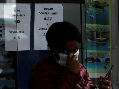 Uma mulher usando uma máscara de proteção sai de uma casa de câmbio no Rio de Janeiro, em fevereiro de 2020.