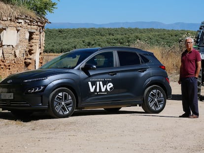 Javier Bollaín, alcalde de Illán de Vacas, con el coche eléctrico de 'carsharing' instalado en su pueblo.