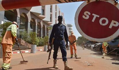 Un policía maliense hace guardia a las puertas del hotel Radisson Blu de Bamako, este lunes.