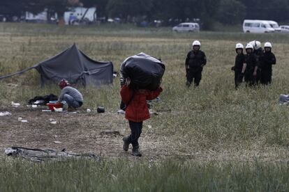 Un niño refugiado traslada sus pertenencias durante la operación que ha iniciado hoy la policía griega de desalojo del campamento improvisado de Idomeni.