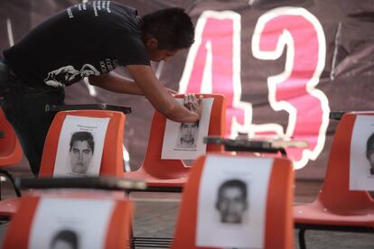 Un alumno de Ayotzinapa pone fotos de los 43.