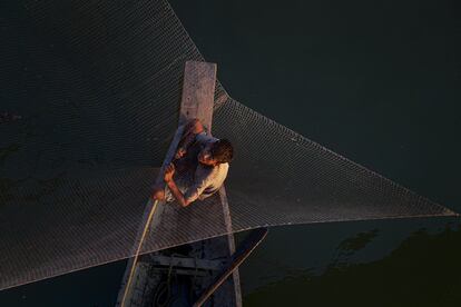 Un pescador prepara su red, en Gauhati (India).