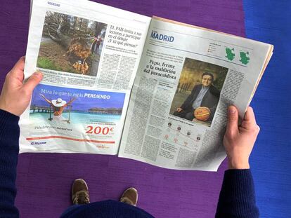 Un lector de El País con un ejemplar del periódico.
