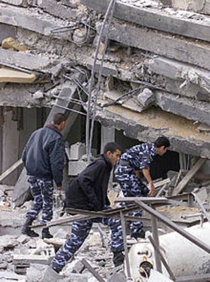 Policías palestinos revisan un edificio alcanzado por bombas israelíes.