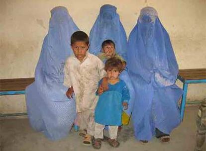 Tres mujeres afganas, vestidas con el burka, y sus hijos, de regreso a su país.