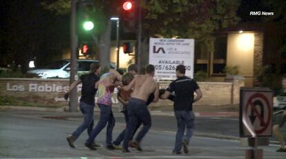 Un grupo de personas ayuda a una de las víctimas heridas en el tiroteo en Thousand Oaks, un suburbio en las afueras de Los Ángeles (California).