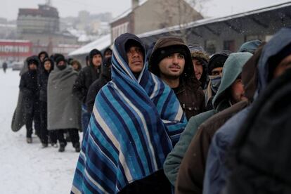 Refugiados esperan un plato de comida en un almac&eacute;n aduanero en Belgrado (Serbia).