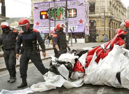 Agentes de la Ertzaintza retiran una pancarta durante su intervención en el recinto festivo de la Aste Nagusia el pasado jueves.