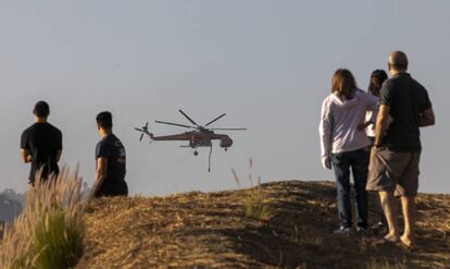 Vecinos de Los Ángeles viendo los trabajos contra el fuego en Brentwood, el lunes.