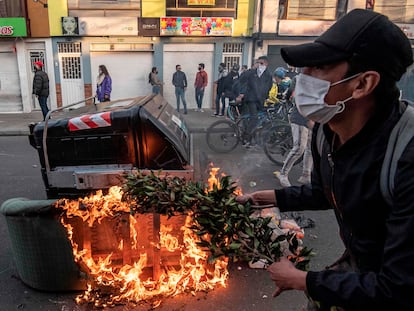 Manifestante ateia fogo em barricadas durante os confrontos com a polícia em Bogotá, após a morte de advogado pelas forças de segurança.