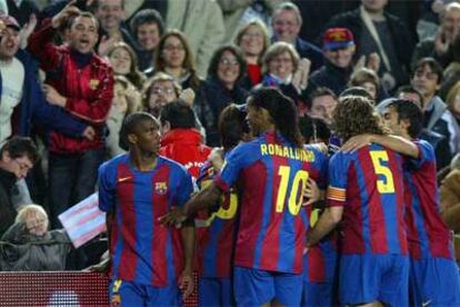 Eto'o, derecha, recibe la felicitación de sus compañeros del Barcelona tras marcar gol al Racing.