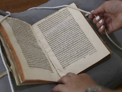Un libro de la Biblioteca Nacional y el separador de hilo utilizado para marcar las páginas que se desean reproducir.