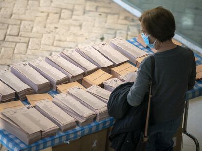 Una mujer elige papeleta antes de votar en las elecciones del 4 de mayo en Madrid.