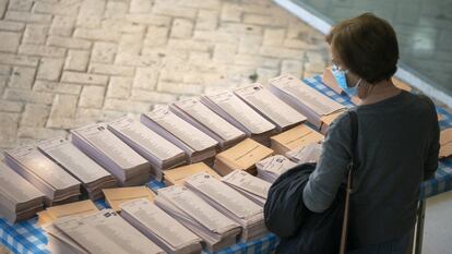 Una mujer elige papeleta antes de votar en las elecciones del 4 de mayo en Madrid.