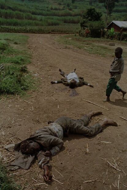 Un niño pasa junto a los cuerpos de dos hutus congoleses.