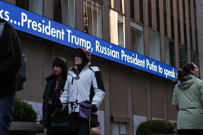 People in New York City walk past a Fox News ticker that displays a headline about U.S. President Donald Trump's call with Russian President Vladimir Putin about a Ukraine ceasefire proposal.