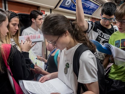Algunos estudiantes repasan en el trayecto en metro hasta Ciudad Universitaria de Madrid durante la EBAU 2019.