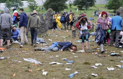 Un joven descansa en el suelo tras una agitada noche en el Festival británico de Glastonbury, 28 de junio de 2013. El festival, que se celebra del 26 al 30 de junio, trae como principal novedad en esta edición la actuación inédita de los Rolling Stones.
