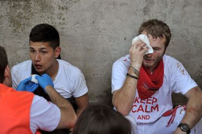 La Cruz Roja, atiende a los heridos en la bajada del callejón de la plaza de toros de Pamplona.