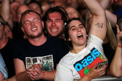 Varias personas disfrutan del concierto ofrecido por Oasis.
