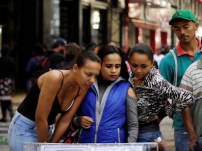 Mulheres consultam ofertas de emprego na rua em São Paulo, no dia 29 de junho
