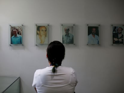 Una mujer observa los retratos de seis sacerdotes jesuitas que fueron asesinados el 16 de noviembre de 1989, el 6 de enero de 2022, en San Salvador (El Salvador).