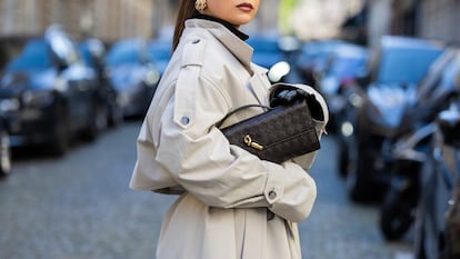 Mujer con una parka de color beige y un bolso negro.