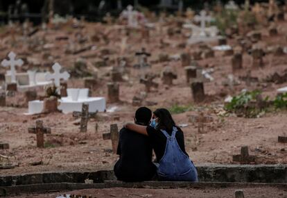 Casal chora a morte de uma mulher vítima de covid-19 sepultada em cemitério do Rio de Janeiro na terça-feira.