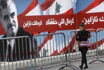 Una mujer pasea por el centro de Beirut junto a un póster en recuerdo del ex primer ministro libanés Rafic Hariri, asesinado el 14 de febrero de 2005.