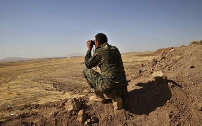 Un peshmerga kurdo observa a tanques del Estado Isl&aacute;mico en Irak.