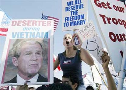 Una partidaria de Bush grita a favor del presidente, rodeada de carteles contrarios a él, el jueves en California.