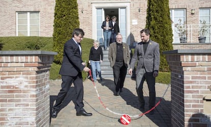 Puigdemont retira la cadena de la entrada de su casa de Waterloo, en febrero de este año.