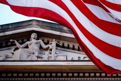 In this March 22, 2019 file photo, an American flag flies outside the Department of Justice in Washington.