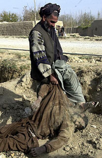 Un afgano da una patada al cadáver de un combatiente extranjero en Mazar-i-Sharif.
