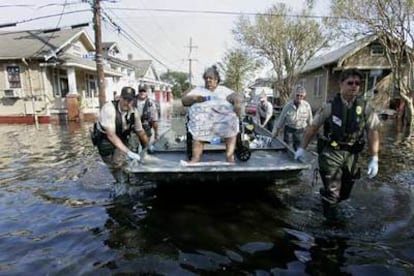 Policías llevan en una lancha a Rose Lee Branch, de 72 años, para evacuarla en helicóptero de Nueva Orleans.