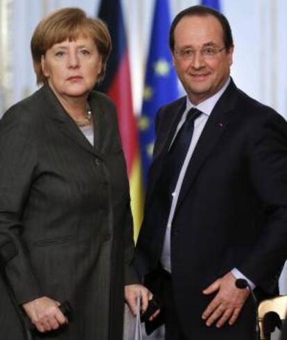 La canciller alemana, Angela Merkel (i), y el presidente francés, François Hollande, se disponen a tomar asiento antes de comparecer en una rueda de prensa durante el encuentro que mantuvieron en el palacio del Elíseo en París, Francia.