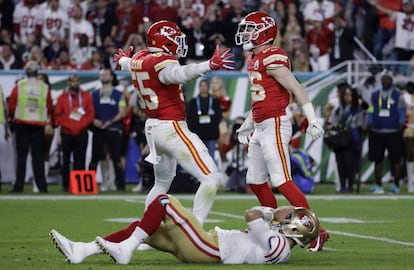 Los jugadores Frank Clark y Ben Niemann celebran la victoria. 