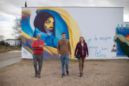 La familia de Ana Isabel García Llorente (Gata Cattana) frente a un mural de su hija en Adamuz, Córdoba, el 8 de febrero. De izquierda a derecha: Andrés (el padre), Antonio (el hermano) y Ana (la madre).  

 