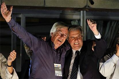 Tabaré Vázquez (a la derecha) saluda a sus partidarios abrazado al futuro ministro de Economía, Danilo Astori.
