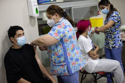 Dos personas reciben una dosis de la vacuna contra la covid-19, en Santiago, Chile.