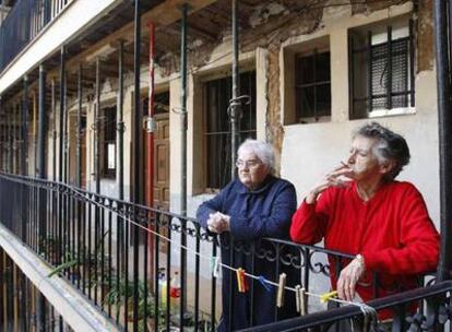 Arriba, vecinas del edificio de la calle de Ventorrillo, 7; abajo, una corrala en la calle de Huerta del Bayo, 9. Ambos, sin rehabilitar.