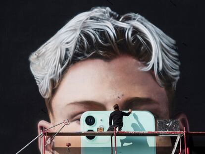 Un artista pinta un mural para el fabricante de teléfonos inteligentes Apple, en Berlín, en octubre de 2020.