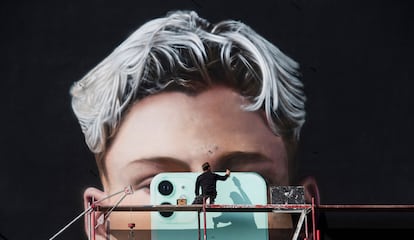 Un artista pinta un mural para el fabricante de teléfonos inteligentes Apple, en Berlín, en octubre de 2020.