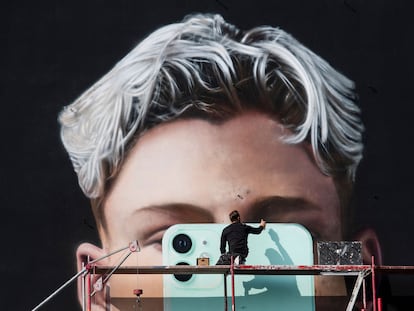 Un artista pinta un mural para el fabricante de teléfonos inteligentes Apple, en Berlín, en octubre de 2020.