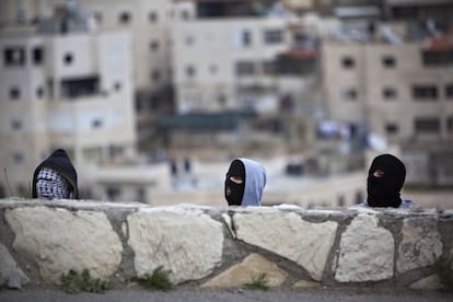 Manifestantes palestinos se refugian durante los enfrentamientos con las tropas israelíes, en Jerusalén.