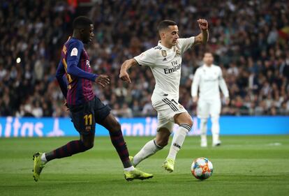 El extremos del Real Madrid, Lucas Vázquez, controla el balón ante Dembélé, del Barcelona.