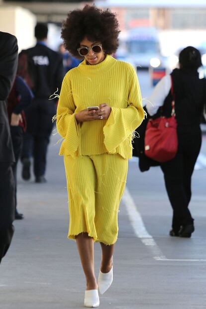 Solange Knowles se dejó ver de amarillo en el aeropuerto de Los Angeles. Nos encanta la combinación del conjunto de Marques Almeida con gafas de sol redondas y mules.