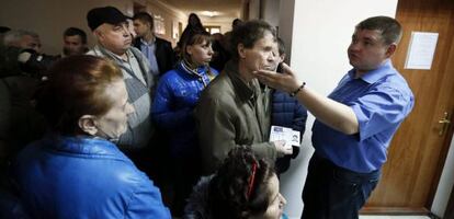 Varias personas esperan para obtener el pasaporte ruso, este jueves en una oficina de Simferópol.