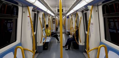 Dos viajeros en el Metro de Madrid.